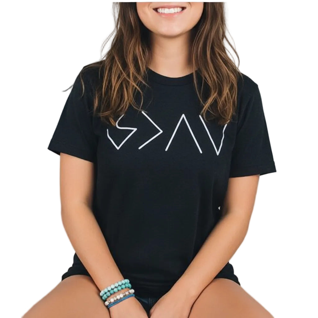 Person wearing a black t-shirt with white geometric design by a lake
