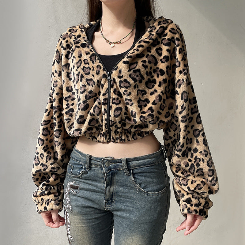 Person wearing a leopard print jacket and jeans against a plain background