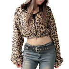 Person wearing a leopard print jacket and jeans against a plain background