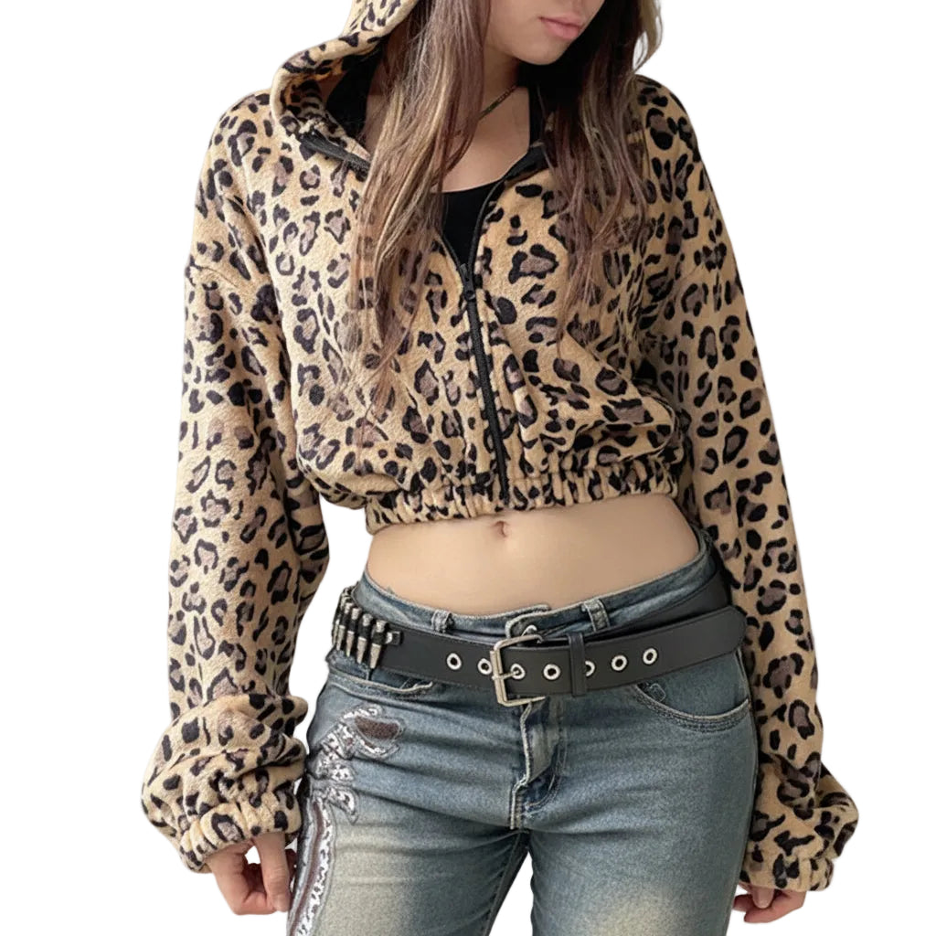 Person wearing a leopard print jacket and jeans against a plain background