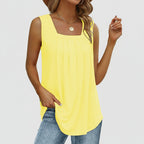 Woman wearing a yellow sleeveless top and blue jeans on a white background