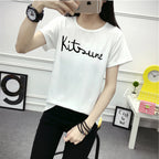 Person wearing a white t-shirt with 'Kitson' text in a casual setting.