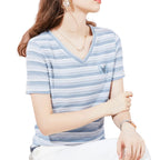 Woman wearing a blue and white striped shirt sitting on a couch.