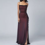 Burgundy evening gown with a slit on a white background