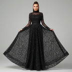 Woman wearing a black sequin dress with sheer sleeves in an indoor setting.