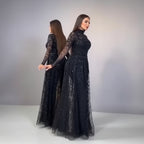 Woman wearing a black sequin dress against a neutral background