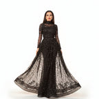 Black sheer evening gown with long sleeves and a flowing skirt on a neutral background
