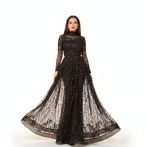 Black sheer evening gown with long sleeves and a flowing skirt on a neutral background